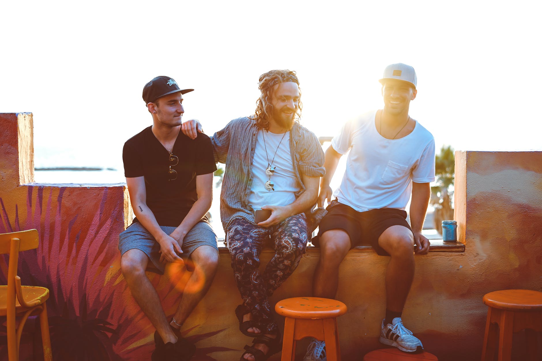 three men sitting on veranda