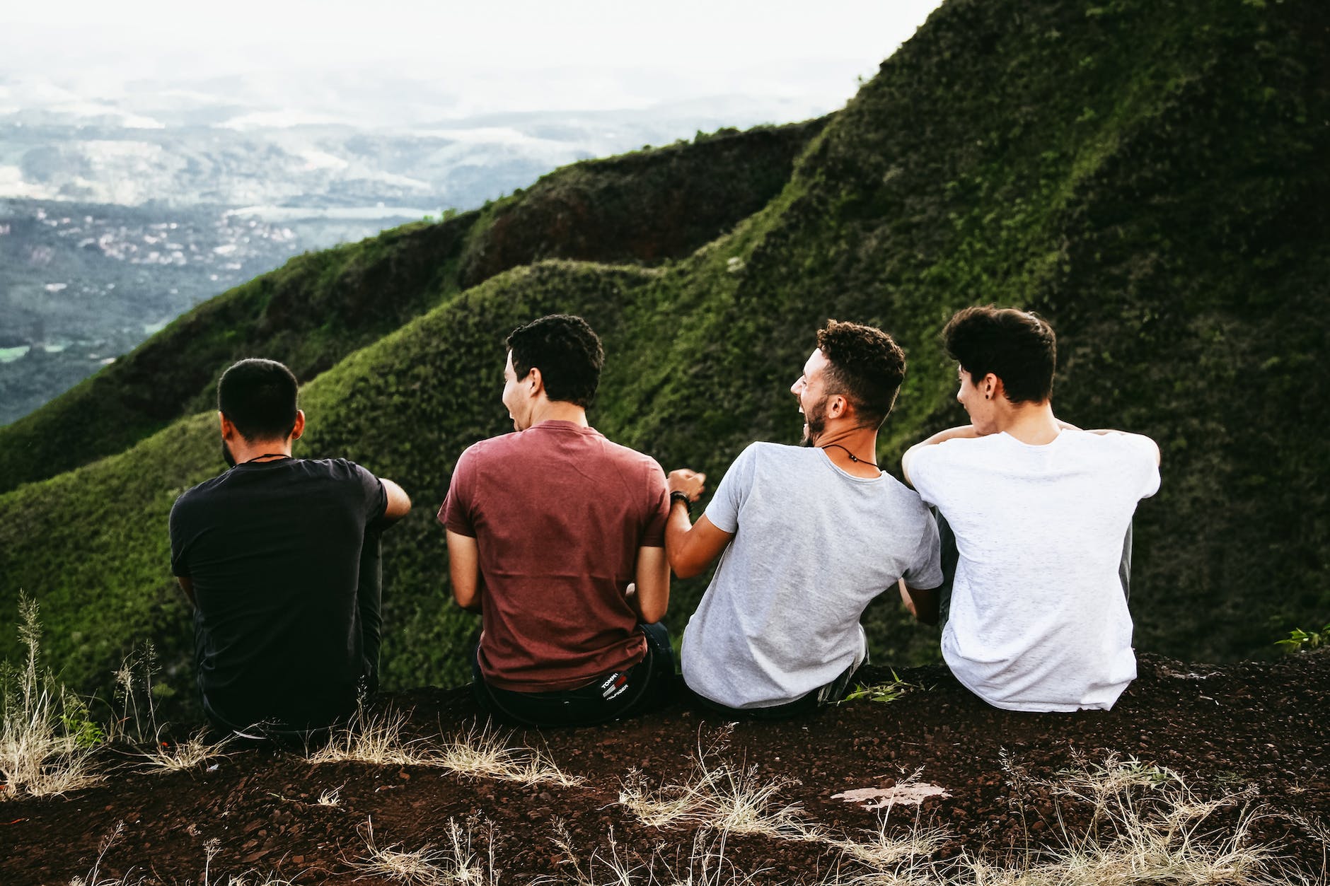 four men sitting on ground